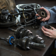 Mechanik trzymający w dłoniach łożysko z układu napędowego