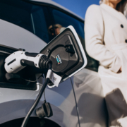 Kobieta obok wtyczki do ładowania samochodu elektrycznego